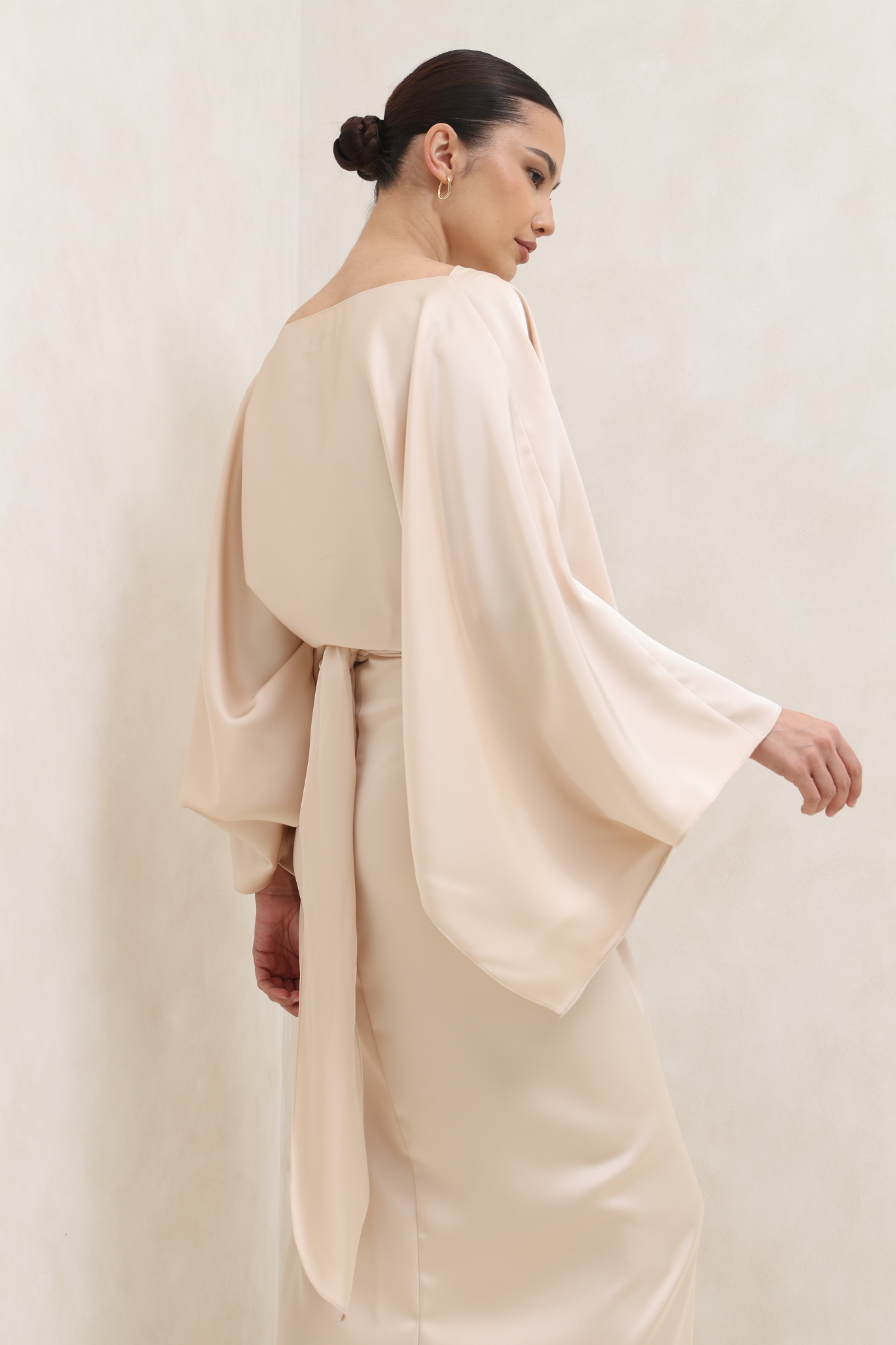 فستان البيج بتصميم ملتف وأكمام كيب انسيابية