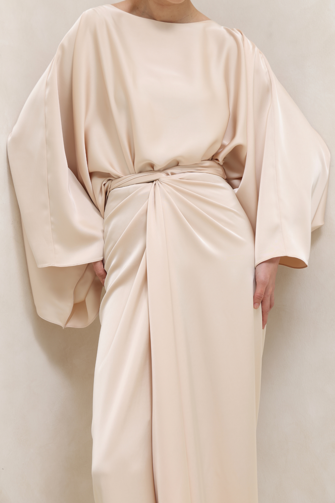 فستان البيج بتصميم ملتف وأكمام كيب انسيابية