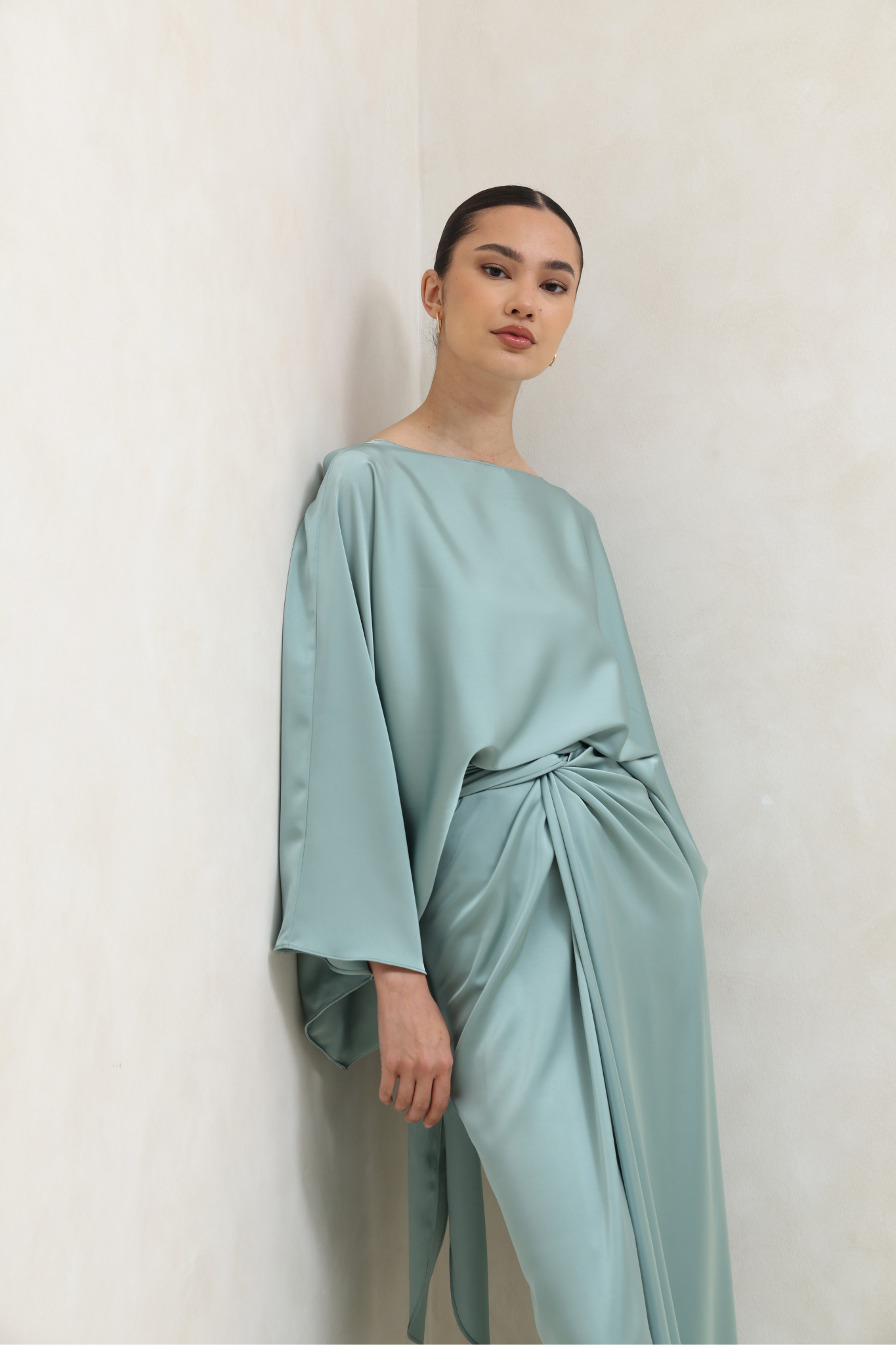 فستان أخضر بتصميم ملتف وأكمام كيب انسيابية