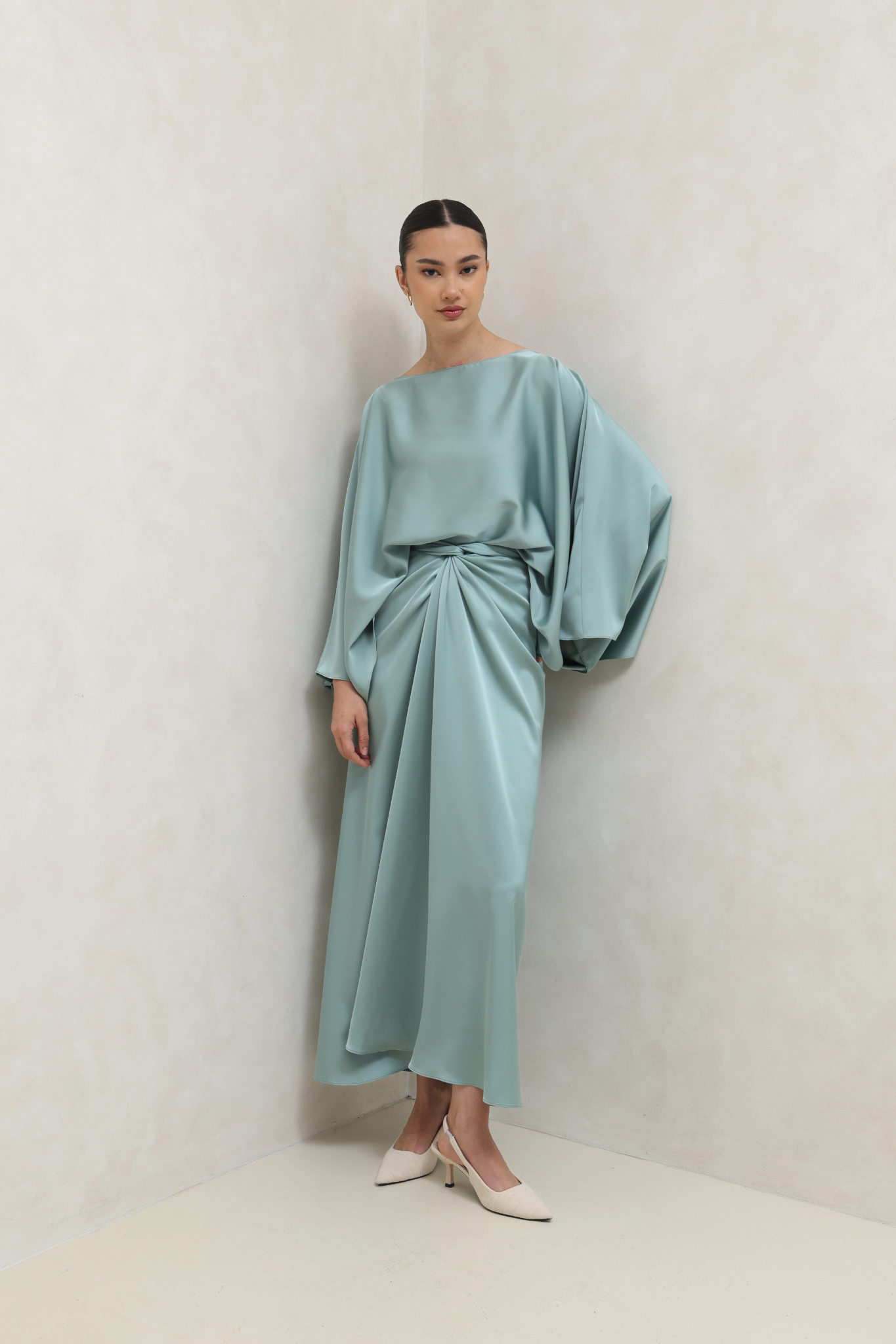 فستان أخضر بتصميم ملتف وأكمام كيب انسيابية