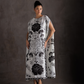 Woman wearing a black and white floral dress against a dark background