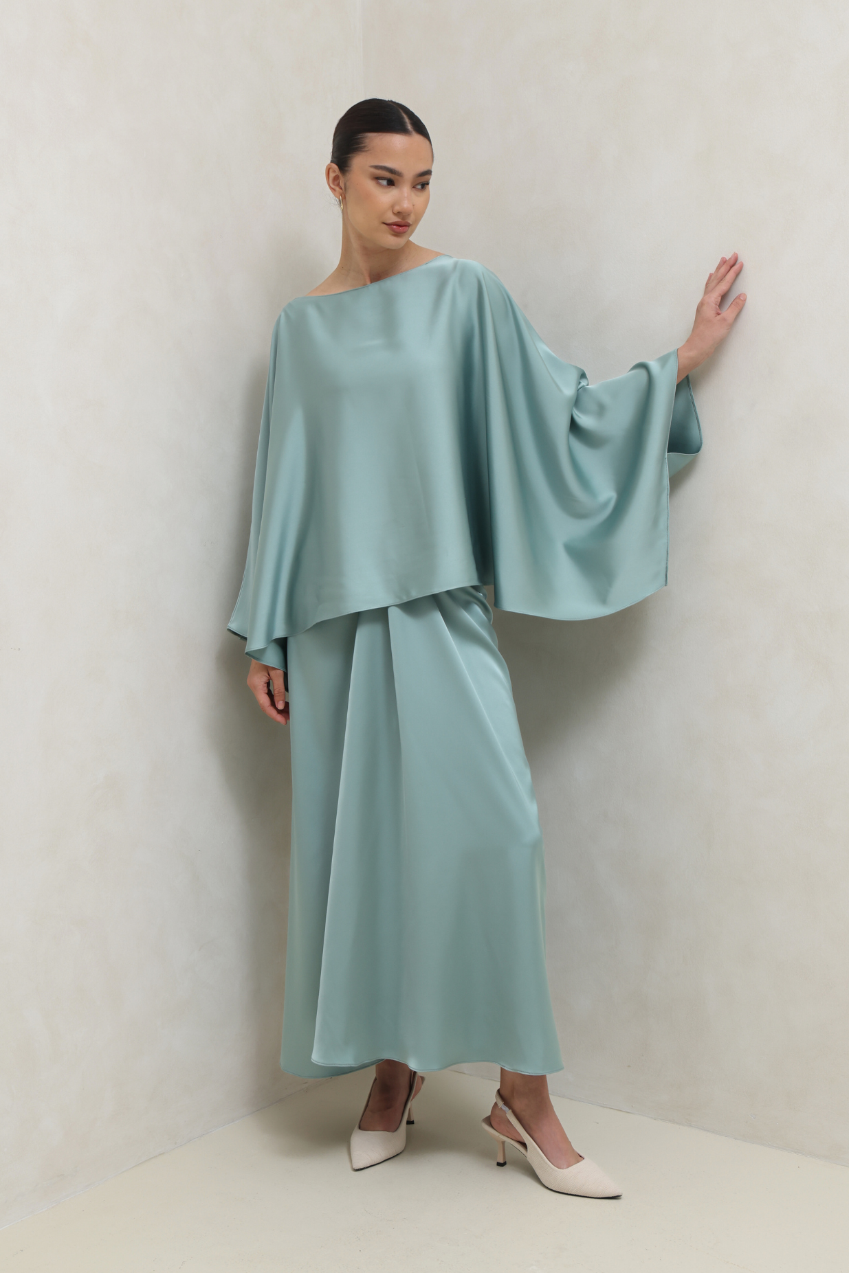 Woman wearing a light blue outfit against a plain background
