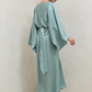 Woman wearing a light blue dress against a plain background