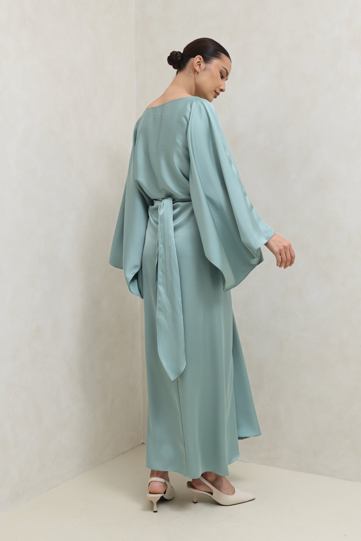 Woman wearing a light blue dress against a plain background